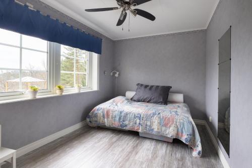 a bedroom with a bed and a ceiling fan at Fantastisk Villa med extra allt in Tyresö
