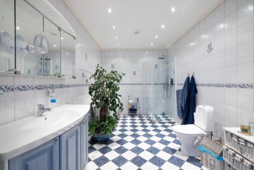 a bathroom with a toilet and a sink and a plant at Fantastisk Villa med extra allt in Tyresö