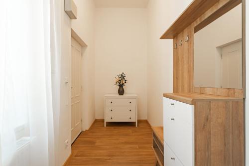 a kitchen with white cabinets and a dresser at Resort Červený dvůr in Rapotín