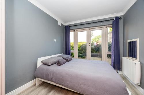 a bedroom with a bed and a large window at Cosy 2-Bedroom Apartment near Airport in Dublin