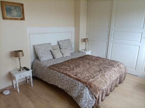 une chambre avec un grand lit avec des oreillers dans l'établissement Chambre double 1er etage, à Ploemeur