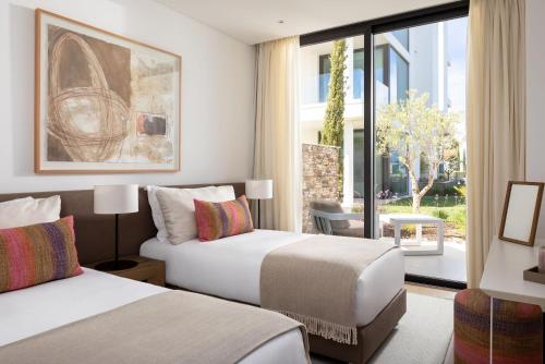 una camera d'albergo con due letti e una finestra di Monte Rei 1 bed apt a Vila Nova de Cacela