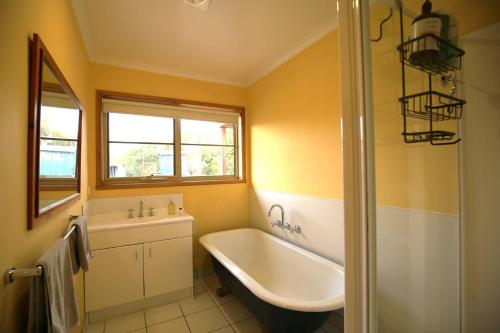 ein Badezimmer mit Badewanne und Waschbecken in der Unterkunft Bridgecroft Bungalow in Richmond