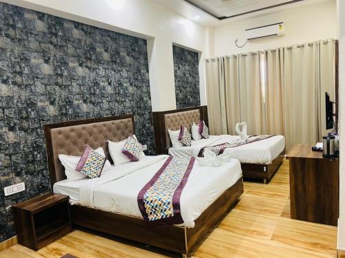 two beds in a hotel room with two bedsvisor at Hotel S V Grand in Varanasi