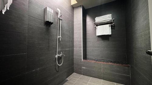 a black bathroom with a shower with a mirror at Kiwi Express Hotel-Taichung Station II in Taichung
