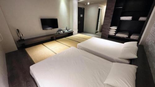 a hotel room with two beds and a television at Kiwi Express Hotel-Taichung Station II in Taichung