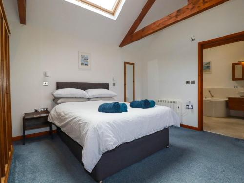 a bedroom with a bed with two blue pillows on it at Little Chywoon Barn in Truro