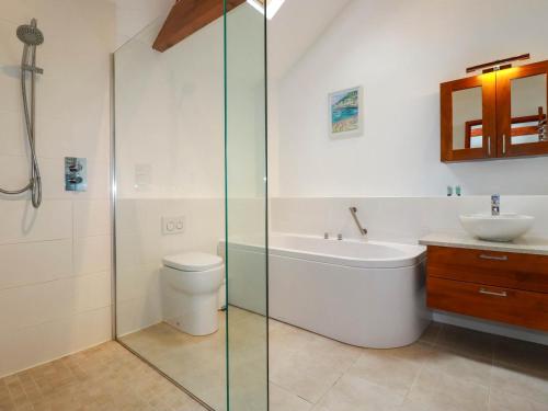 a bathroom with a tub and a toilet and a sink at Little Chywoon Barn in Truro
