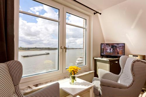 Zimmer mit einem Fenster und Blick auf das Wasser in der Unterkunft Fährmann im Häuschen am Rhein in Rees