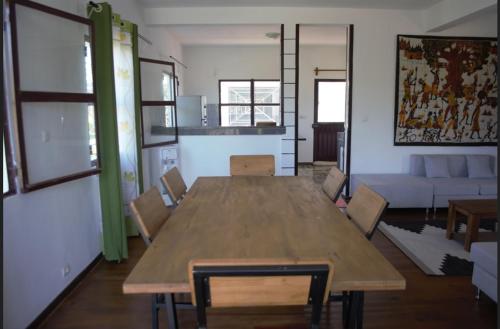 a living room with a wooden table and chairs at Antsaly Lodge in Anjomakely