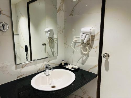 a bathroom with a sink and a mirror at Mayur Belgaum Presidency Hotel & Spa in Belgaum