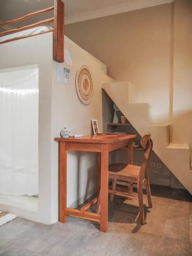 a wooden desk with a chair next to a staircase at Secret Spot Surf and Stay in Kuta Lombok