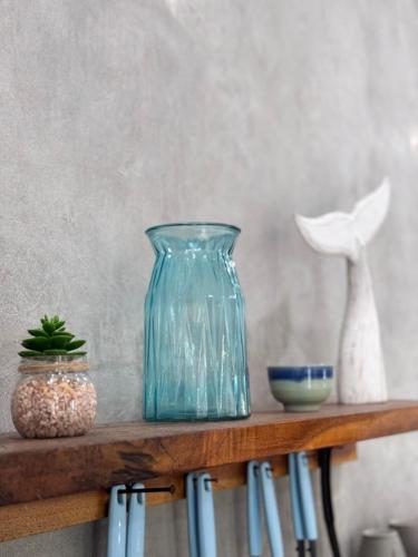 a blue glass vase sitting on top of a shelf at Secret Spot Surf and Stay in Kuta Lombok