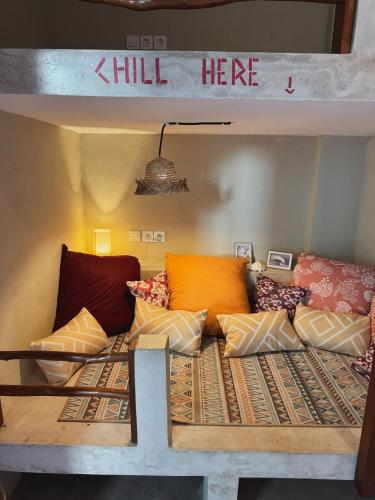 a bed with a bunch of pillows on it at Secret Spot Surf and Stay in Kuta Lombok
