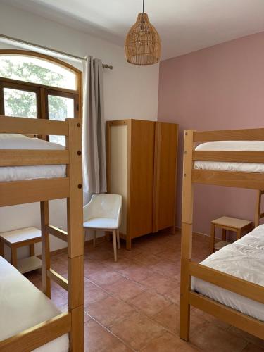 Ce dortoir comprend des lits superposés, un bureau et une chaise. dans l'établissement Chez Maï Gîte de Novella, à Novella