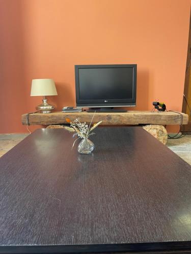 d'un salon avec une télévision et une table avec un sidx dans l'établissement Chez Maï Gîte de Novella, à Novella