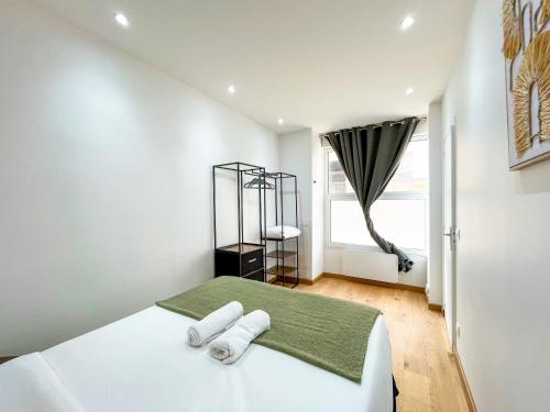 une chambre blanche avec un lit avec des serviettes dessus dans l'établissement Urban Flat 198 - Townhouse Basfroi, à Paris