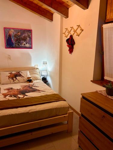 Un dormitorio con una cama y un cuadro en la pared. en appartamento antonella, en Brentonico