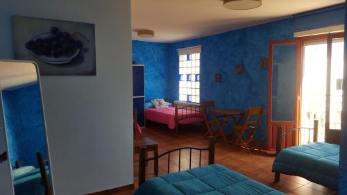 un soggiorno con pareti blu e tavolo e sedie di Hostal A La Sombra Del Laurel a Navarrete