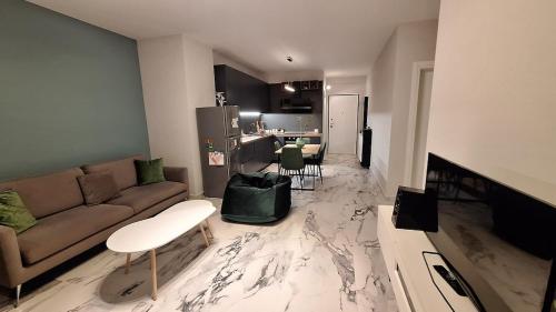 a living room with a couch and a kitchen at White Palace in Vlorë