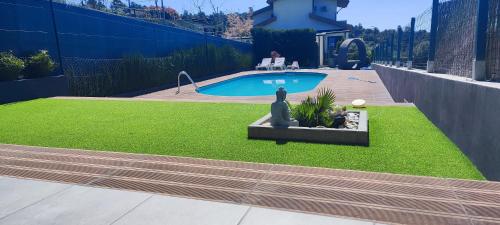 a yard with a pool and a statue in the grass at La Cigarrita Guest House - Douro Valley in Peso da Régua