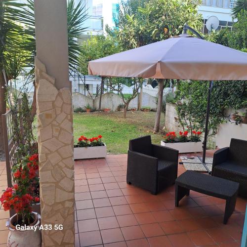 a patio with two chairs and an umbrella at Casa Anna in Francavilla al Mare
