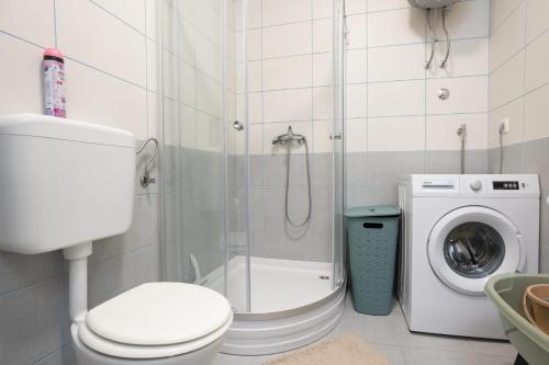 a bathroom with a toilet and a washing machine at Mima in Neum