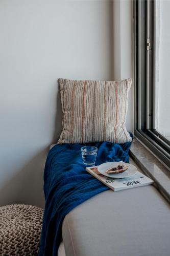a bed with a pillow and a plate of food on it at Seannamon Apartment with sea view by 8essentially in Agios Nikolaos