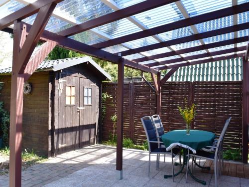 a patio with a table and chairs under a pergola at Ferienhaus am Dümmer See, Perlin in Perlin