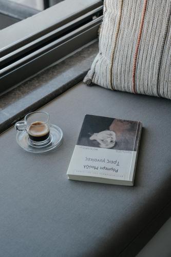 a book sitting on a table next to a cup of coffee at Seannamon Apartment with sea view by 8essentially in Agios Nikolaos