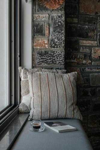 a living room with a couch and a brick wall at Seannamon Apartment with sea view by 8essentially in Agios Nikolaos