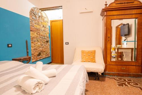 ein Schlafzimmer mit einem Bett, einem Stuhl und einem Spiegel in der Unterkunft Lovingenoa - Ducale - Old Stone in Genua