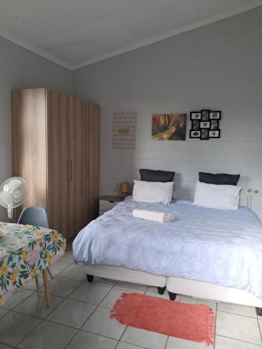 a bedroom with a large bed and a table at Phindulo Bed and Breakfast - No Loadshedding, Smart TVs & unlimited free fibre wifi in Krugersdorp
