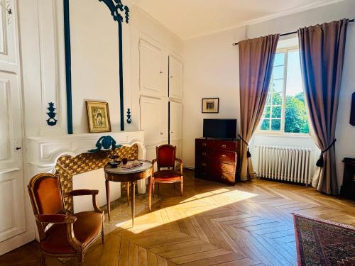 a living room with a table and chairs at Château du Mesnil Soleil , gites et chambres d'hôtes in Damblainville