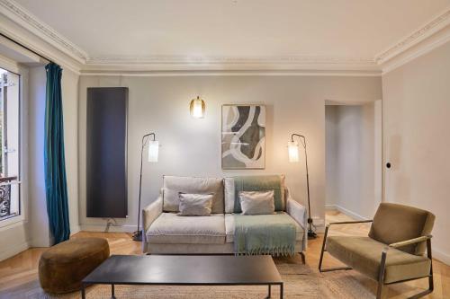 un salon avec un canapé et une chaise dans l'établissement Magnificent apartment - 3BR- 8P - Batignolles, à Paris