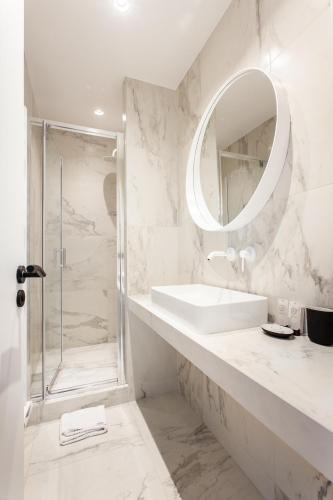 une salle de bain blanche avec un lavabo et un miroir dans l'établissement Magnificent apartment - 3BR- 8P - Batignolles, à Paris
