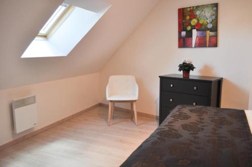 a bedroom with a bed and a chair and a skylight at Le Clos Saint Martin in Laon