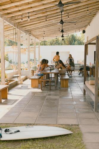 a group of people sitting at tables with surfboards on the floor at Global Surf Lodge Kabalana in Ahangama