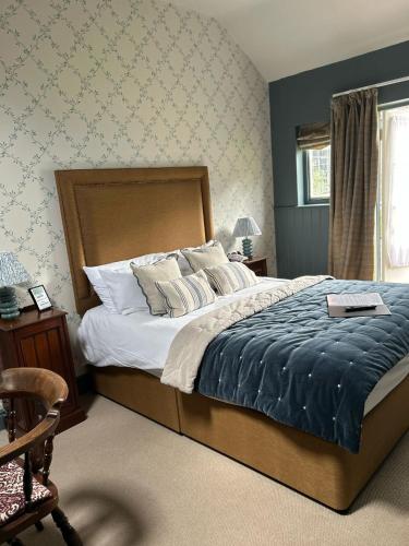a bedroom with a large bed with a blue blanket at Ravenwood Hall Hotel in Bury Saint Edmunds