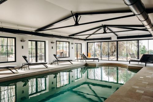 - une piscine intérieure avec des chaises et des fenêtres dans l'établissement Villa de prestige I Vue Mer - Piscine intérieure, à Villerville