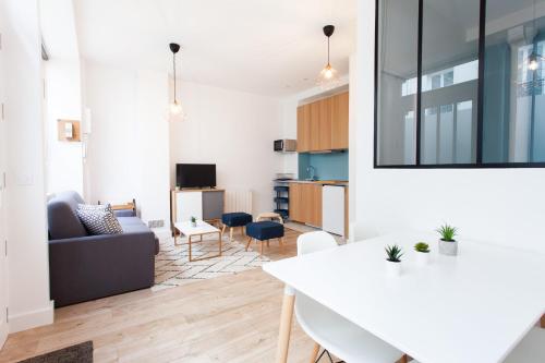 un salon avec un canapé et une table dans l'établissement Luminous and design Close To The Sacred Heart, à Paris