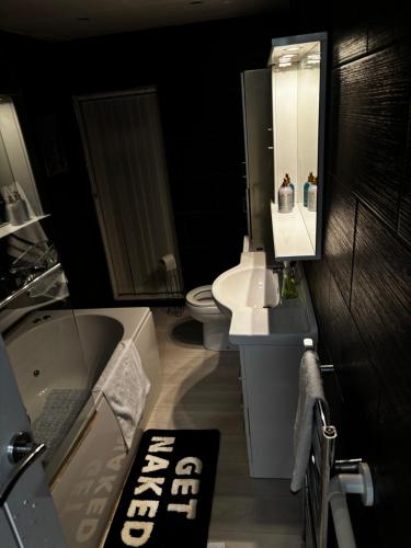 a bathroom with a sink and a tub and a toilet at Divine Place in Bloxwich