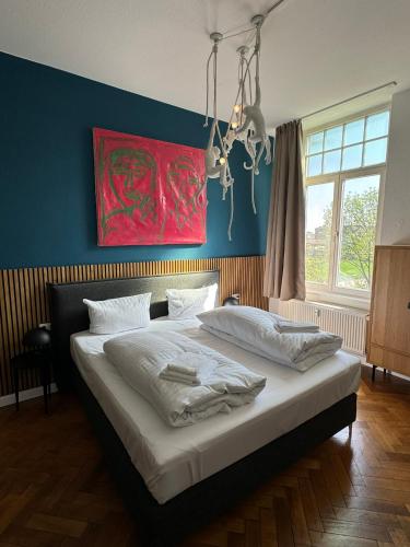 a bedroom with a large bed with a red painting on the wall at Lio Suite Design Apartment Balkon Netflix in Minden
