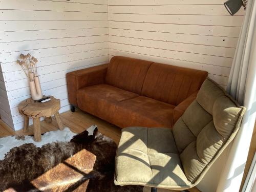 a living room with a couch and a chair at Studio Veerse Meer in Wolphaartsdijk