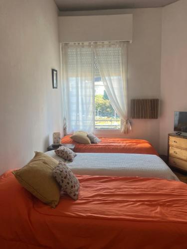 two beds in a bedroom with a window at Corazón obelisco 4 in Buenos Aires