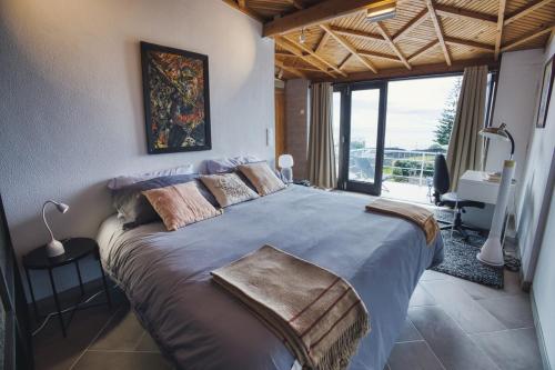 Un dormitorio con una cama grande con una ventana grande. en Azores Awaits, en Ribeira das Tainhas