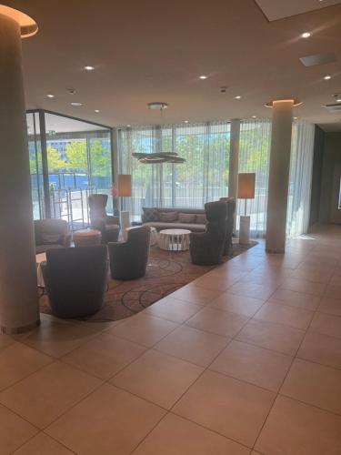 a lobby with couches and chairs in a building at Hampton By Hilton Frankfurt Airport in Frankfurt/Main