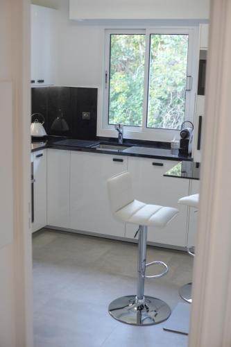 - une cuisine avec des placards blancs, un évier et un tabouret dans l'établissement With balcony Near La Pointe De La Croisette, à Cannes