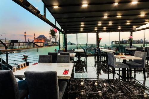 un restaurant avec des tables et des chaises et une vue sur la ville dans l'établissement Aristocrat Hotel, à Istanbul