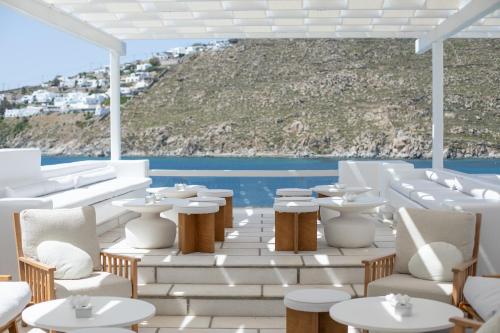 a restaurant with white tables and white chairs at Nissaki Boutique Hotel in Platis Yialos Mykonos